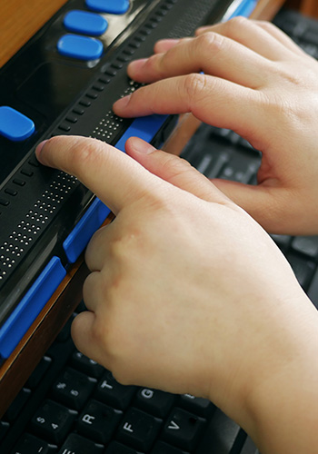 Blind child hands using braille keyboard